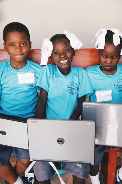 3 black children holding a laptop